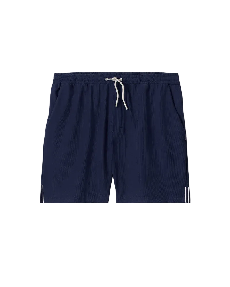 Navy blue swim shorts with a white drawstring on a beige background