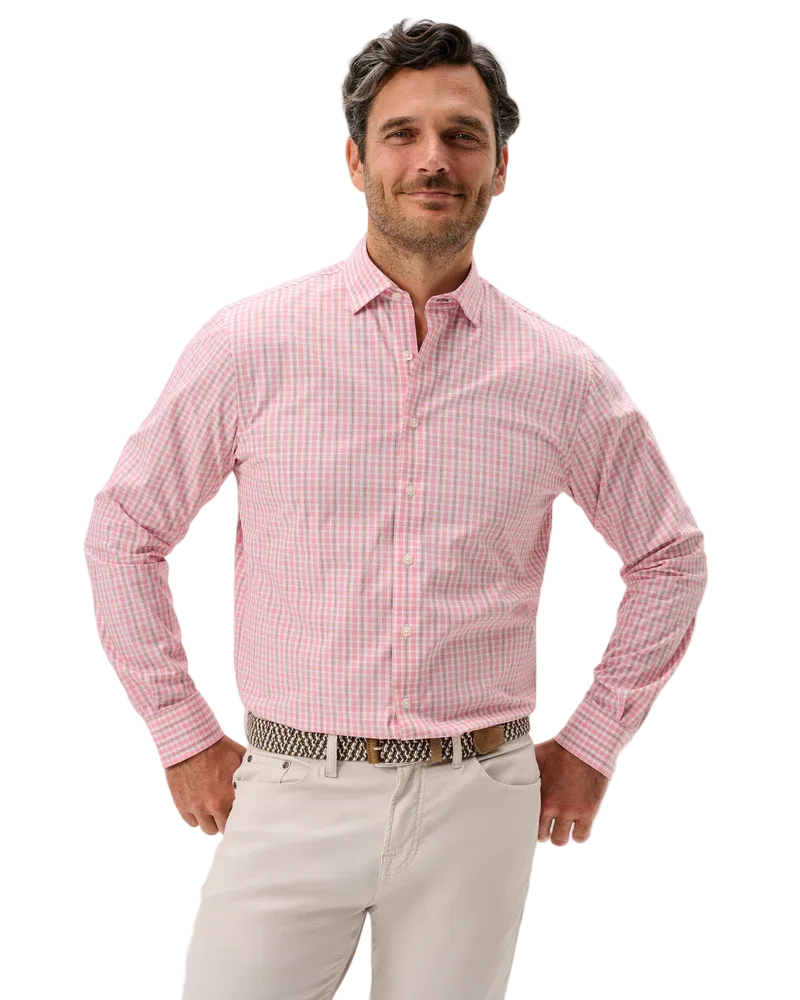 Man wearing a pink checkered shirt and white pants on a light gray background
