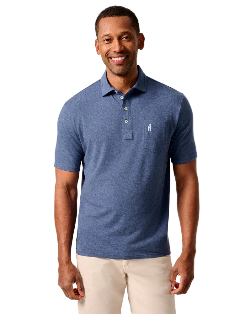 Man wearing a blue polo shirt with a logo on a beige background
