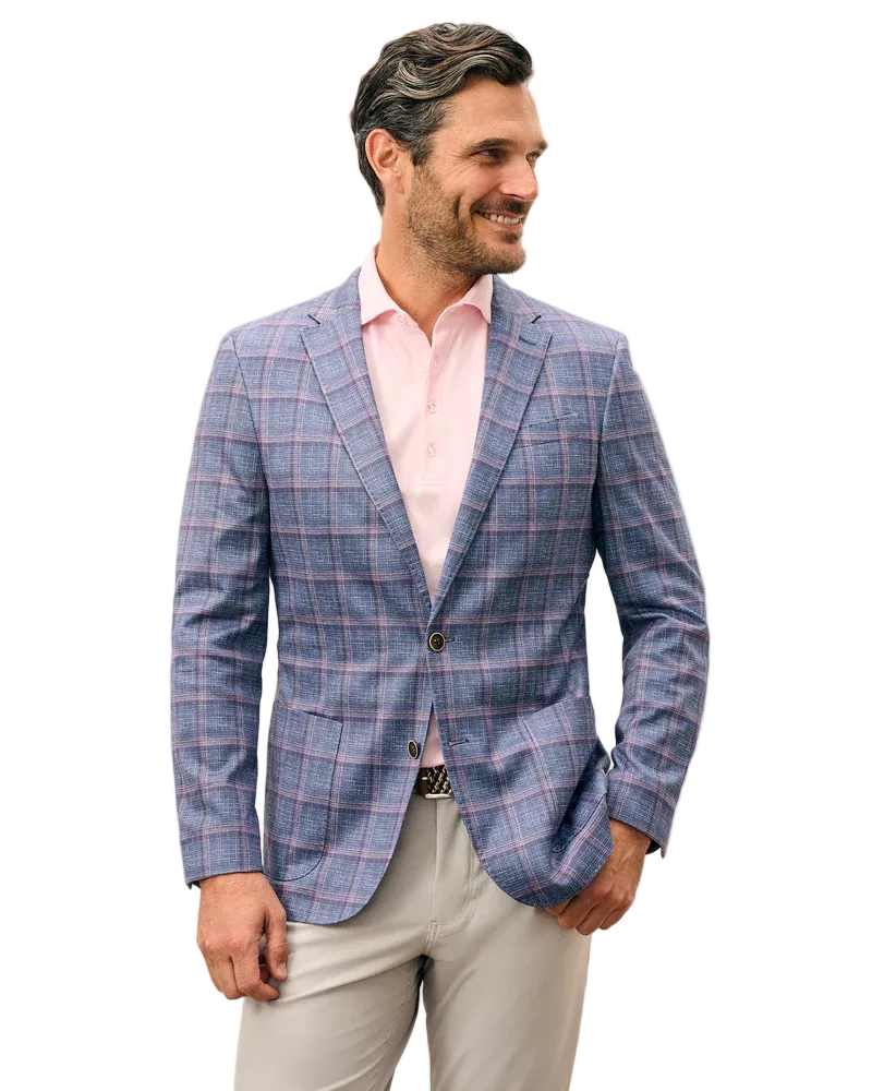 Man wearing a blue checkered blazer over a pink shirt on a white background