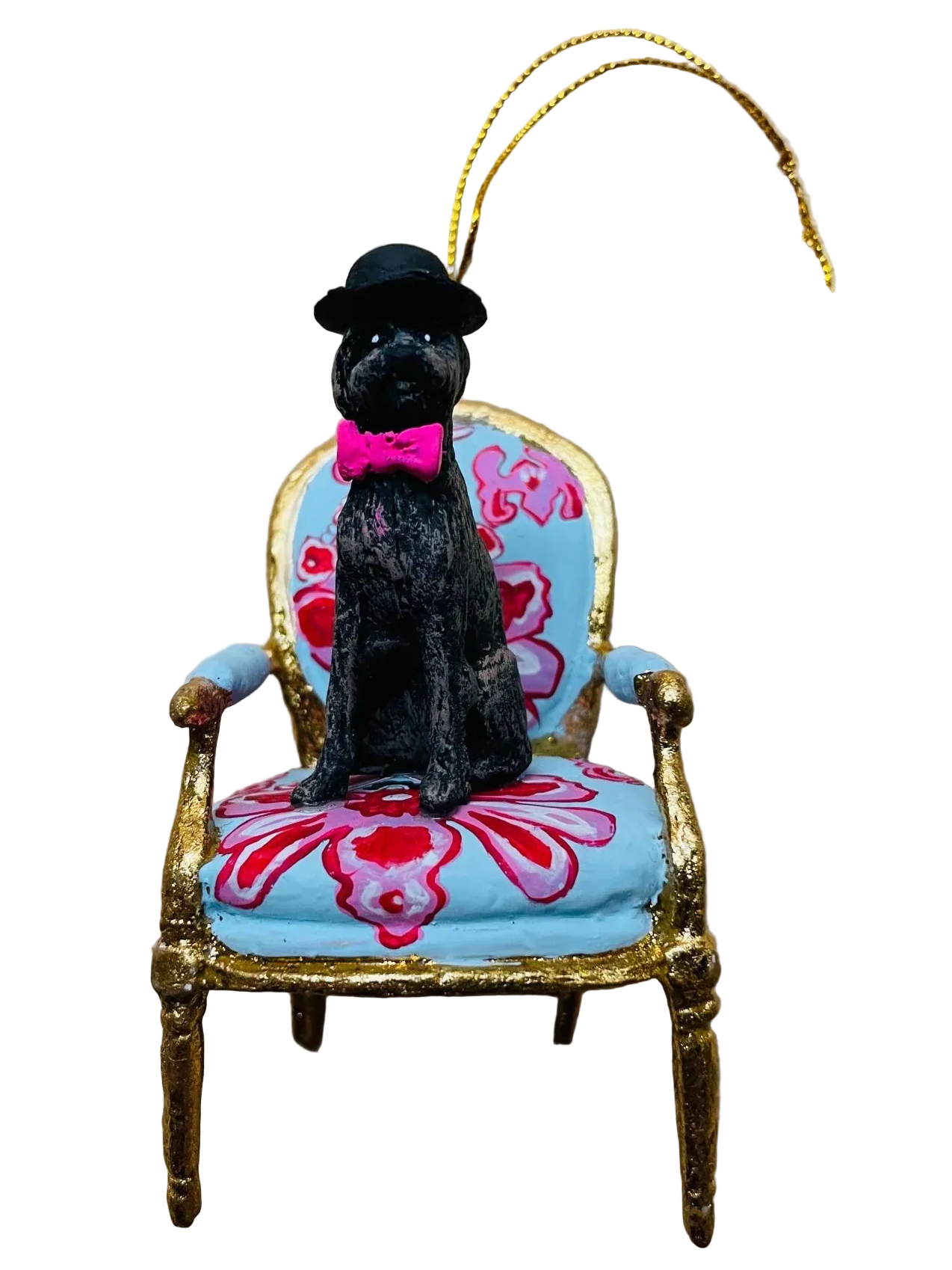 Decorative ornament of a black dog in a top hat and pink bow tie sitting on a gold and blue chair with a pink cushion.