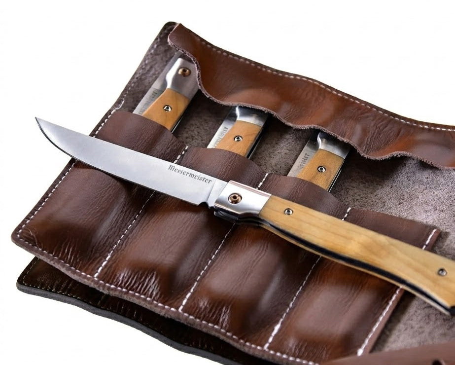 Set of folding knives with wooden handles in a brown leather case on a white background