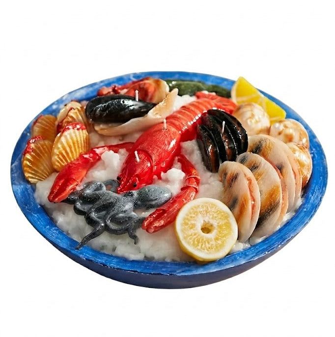 Seafood pasta dish with lobster, mussels, and lemon wedge on a white background