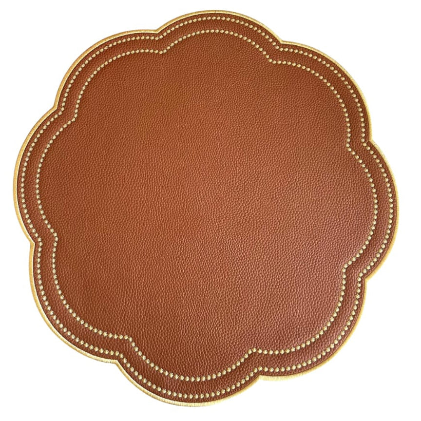 Round brown leather placemat with scalloped edge on a white background
