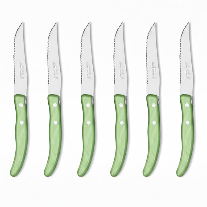 Set of eight steak knives with green handles on a white background